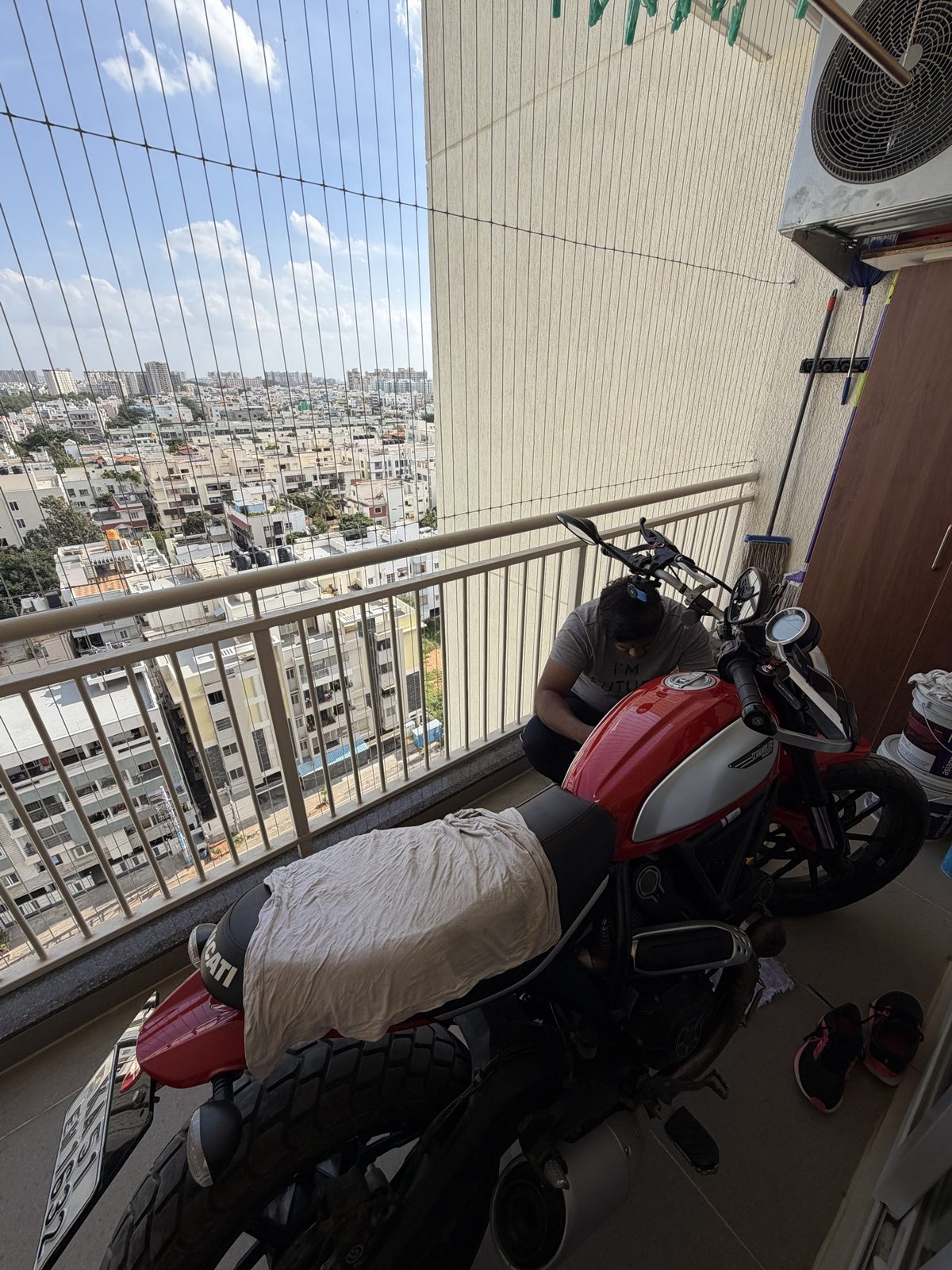 Working on the Scrambler on the balcony, crouched beside the tank