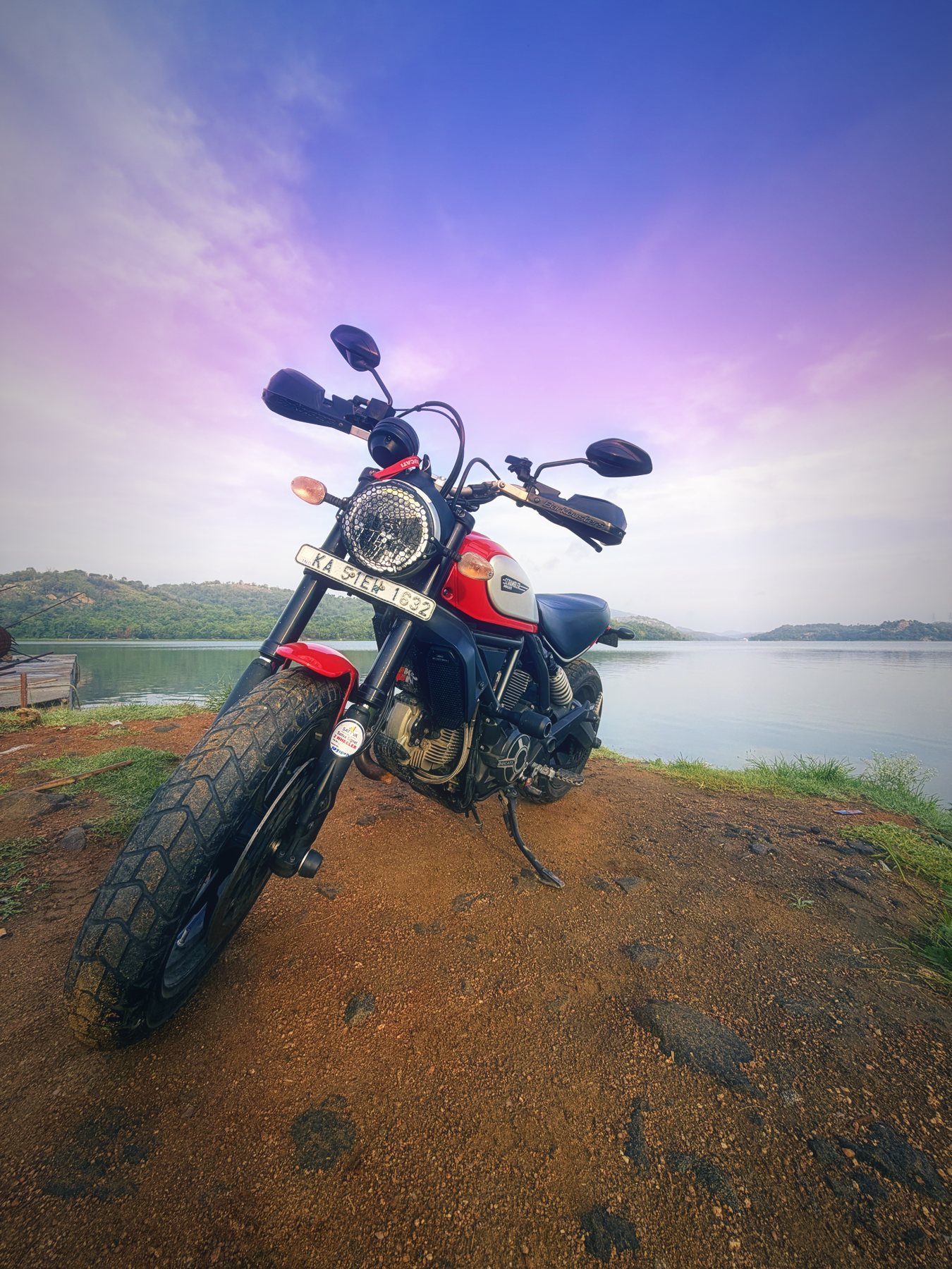 Front view of the Scrambler with Barkbusters handguards and mud on the tyres